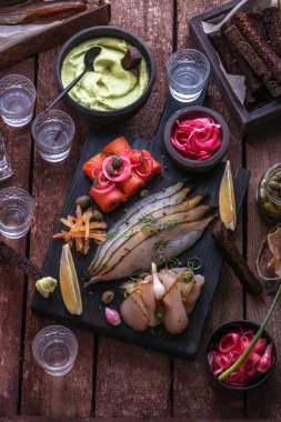 Votka çekim ile karanlık kesme tahtası üzerinde çeşitli korunmuş balık.