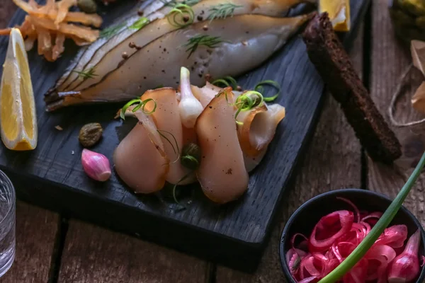 Votka çekim ile karanlık kesme tahtası üzerinde çeşitli Marine balık.