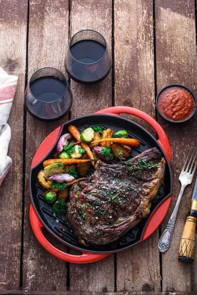 Steak de boeuf grillé sur grille poêle en fer sur fond en bois — Photo