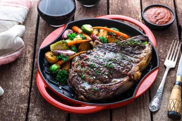 Sulu biftek biftek kapatmak kök sebzeler ile dökme demir tava üzerinde görünümü