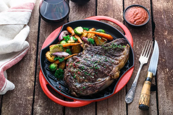 Sappige biefstuk sluit weergave op ijzer gegoten pan met wortelgroenten — Stockfoto
