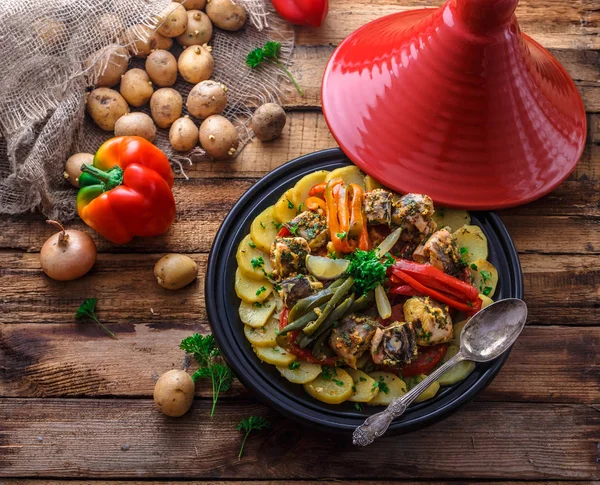 Fish tajine mqualli with potato and bell peppers, top view