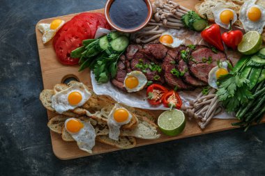 Kahvaltı yemek çeşitli düz yatıyordu. Et, yumurta, sebze, ekmek vb ile açık büfe ahşap tahta üzerinde üstten görünüm