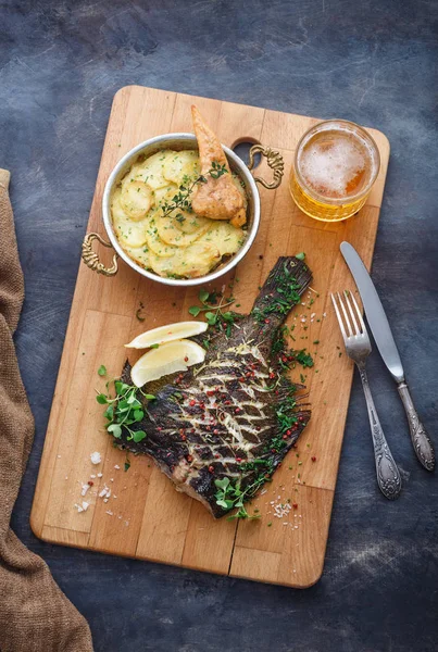 Heerlijk gebakken platvis met aardappelgratin en bier, bovenaanzicht. — Stockfoto