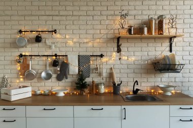 Yeni yıl ve Noel 2018. Noel süslemeleri şenlikli mutfakta. Döşeme mumlar, çam dalları, ahşap stand, Masa.
