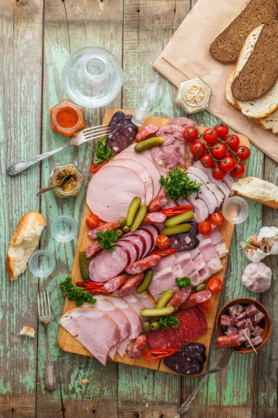 Wurst und Räucherfleisch mit Essiggurken, Brot und Wodka auf Holzbrett, Kopierraum von oben — Stockfoto