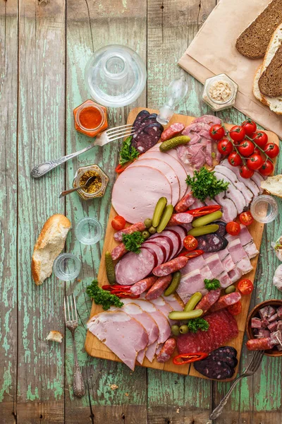 Wurst und Räucherfleisch mit Essiggurken, Brot und Wodka auf Holzbrett, Kopierraum von oben — Stockfoto