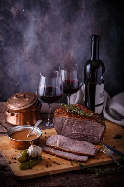 Carne de vită coaptă pe bord de tăiere din lemn cu sos, murături și vin, spațiu de copiere — Fotografie, imagine de stoc