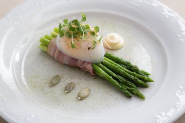 Bir plaka üzerinde yeşil kuşkonmaz ile Onsen tamago