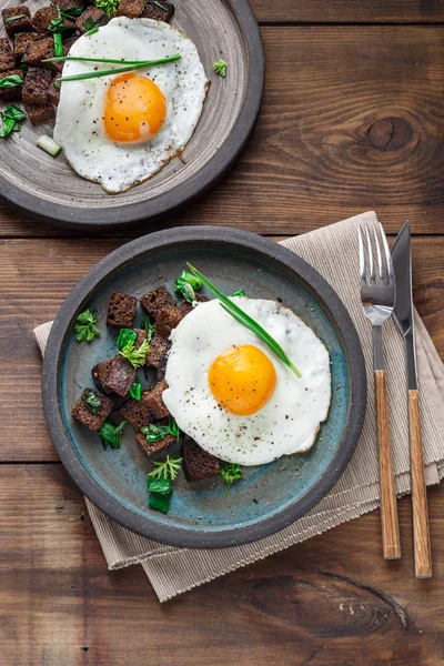 Sunny side fried egg with croutons and herbs, close view — Stock Photo, Image