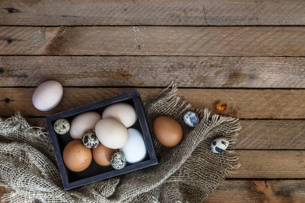 Сельскохозяйственные яйца на фоне деревянного стола, пространство для копирования
