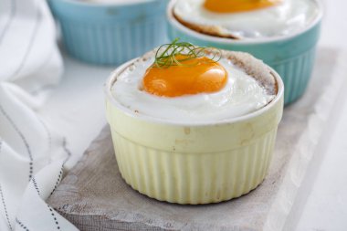 Baked eggs in ramekins close view, selective focus clipart