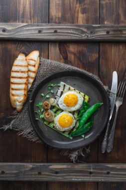 Fried güneşli tarafı yumurta soğan ve kar bezelye, kahvaltı kavramı, karanlık fotoğraf kopyalama alanı ile