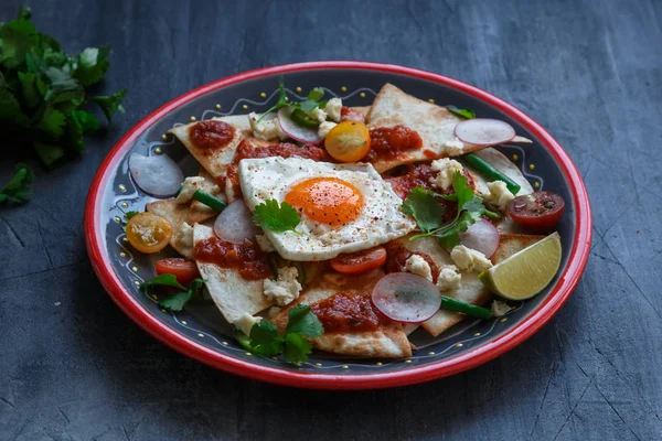 Chilaquiles Tortilla mexicana con salsa de tomate, pollo y huevo de cerca en un plato. Vista horizontal desde arriba — Foto de Stock