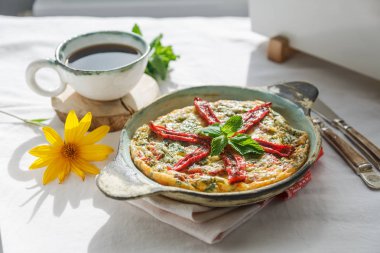 Bir dökme demir tavada kuru domates ile geleneksel fritatta. Beyaz arka plan, kopya alanı