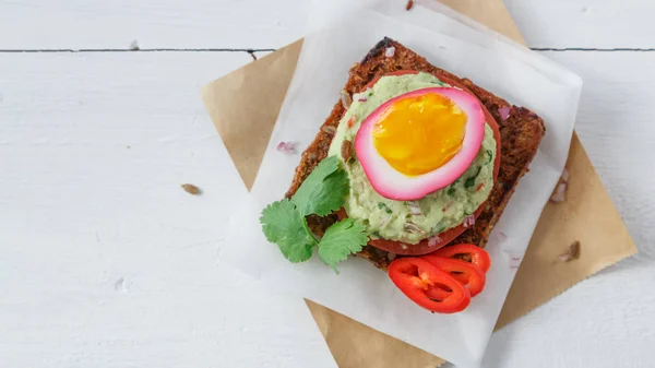 Sandwich con huevos en escabeche de remolacha morada, aguacate y tomate, espacio para copiar . —  Fotos de Stock