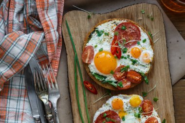 Kızarmış yumurta ve domates tost ahşap kesme tahtası üzerinde