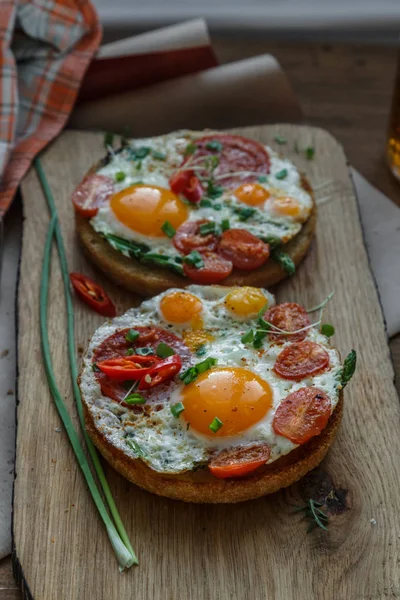 Tostadas con huevos y tomates en tabla de cortar — Foto de Stock