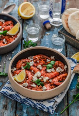 Bir masada bir tabak üzerinde beyaz peynir ile Karides saganaki
