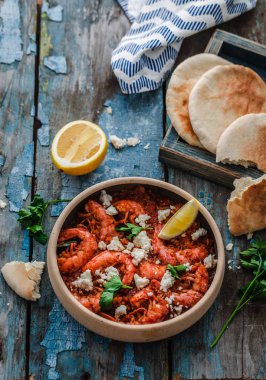 Bir masada bir tabak üzerinde beyaz peynir ile Karides saganaki