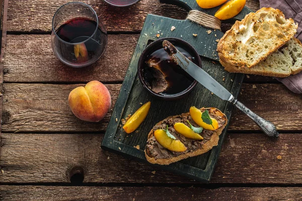 Печёночный паштет с гримированным хлебом и персиком, деревенский стиль — стоковое фото