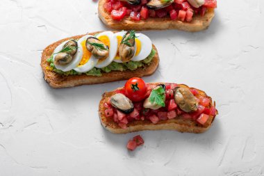Domates, avokado ve yumurta, üst görünüm ile füme midye bruschetas