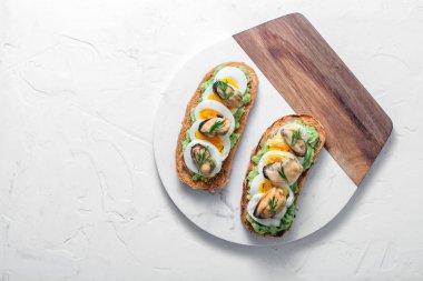 Füme midye ve avokado tost, beyaz arka plan, kopya alanı