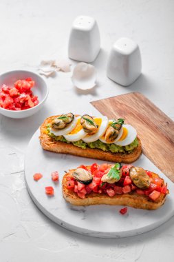 Mermer tahta üzerinde midye ile iki bruschettalar