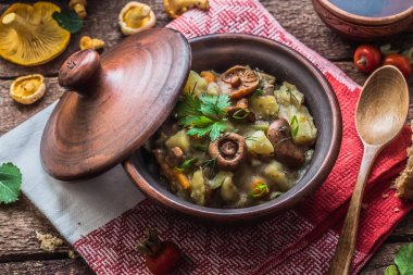 Bir kil pot, rustik tarzı patates ve mantar haşlanmış