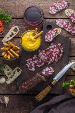 Kırmızı şarap atıştırmalık seti. Salam, chochoves, domates, kabuklu ekmek, düz yatıyordu.