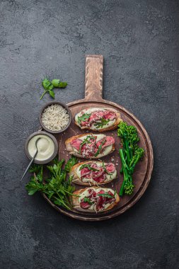 Ahşap tahta üzerinde sığır eti ile Bruschettas, kopya alanı