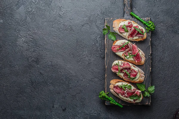 Crostini siyah tahta üzerinde rosto sığır eti ile, kopya alanı düz yatıyordu