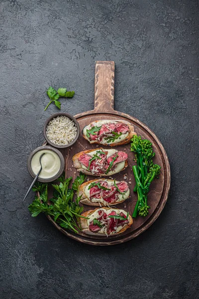 Ahşap tahta üzerinde sığır eti ile Bruschettas, kopya alanı