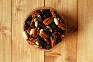 Pekan somun, jumbo siyah kuru üzüm, kızılcık, badem ahşap masa bambu kase kabuğu olmadan karışımı. Portre.