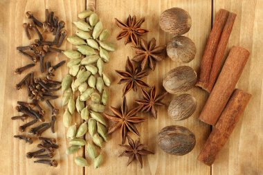 Üstten görünüm kuru baharat karanfil, Kuru yığın yığını üzerinde ham kakule tohumu, Kuru anason baharat demet dağınık, kurutulmuş Hindistan cevizi meyve, Kuru tarçın, ahşap kurullarında yalan