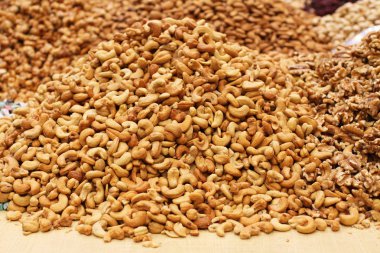 Kavrulmuş tuzlu kaju fıstığı, ham ceviz ve badem, Deira, Dubai pazarda büyük bir tezgahta yatan.