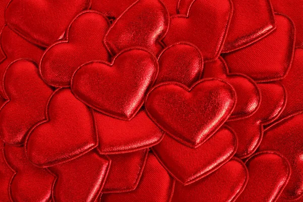 Coeurs en tissu rouge brillant disposés au hasard. Contexte — Photo
