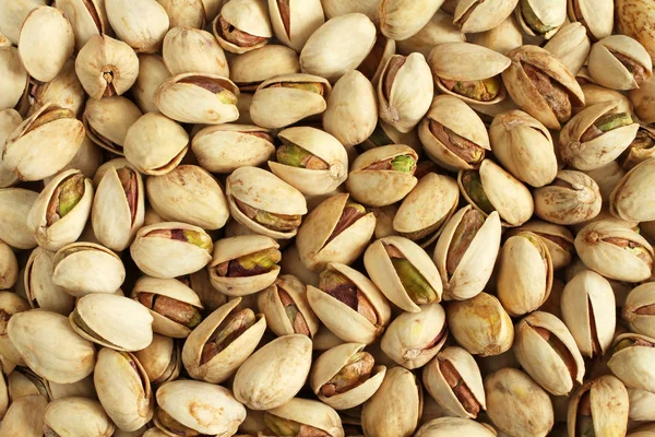 Achtergrond van gezouten pistachenootjes gelegen willekeurig — Gratis stockfoto