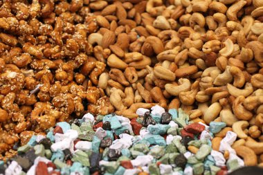 Deve sütü, kavrulmuş kaju fıstığı, kavrulmuş kaju fıstığı susam ile karamel renkli çikolata çiğ badem, Deira, Dubai pazarda büyük bir tezgahta yatan