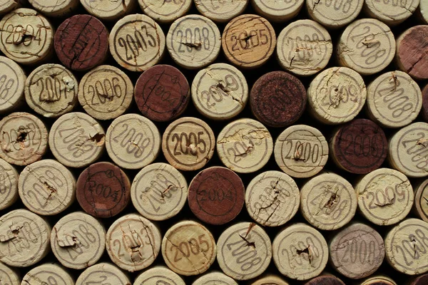 Tapas de botella de vino de corcho con números de años dispuestos uno cerca del otro. Primer plano. — Foto de Stock