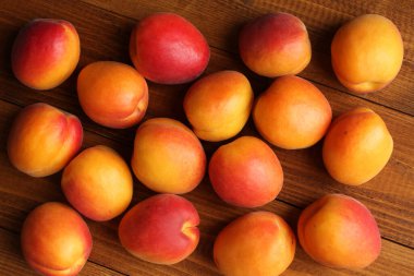 Kahverengi ahşap bir masada olgun kayısılar. Tepeden tırnağa. Yakın çekim.     