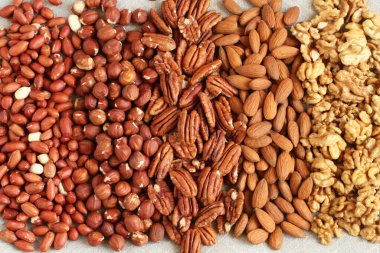 Çiğ fıstık, fındık, ceviz, badem ve keten kumaş üzerinde ceviz. - Yakın çekim. Makro