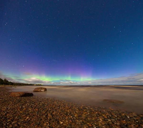göl üzerinde mavi gökyüzünde bulutlar gizemli yeşil ve mor aurora borealis 