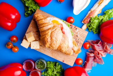 Jambonlu, peynirli, kekikli ve incirli taze kruvasan sandviçi.