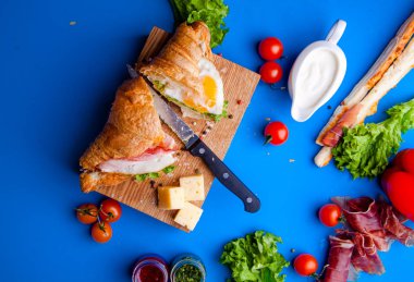 Jambonlu, peynirli, kekikli ve incirli taze kruvasan sandviçi.