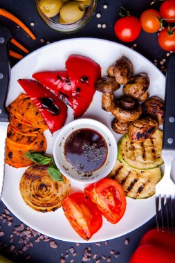 Sebze sulu ızgara sebzeler, çeşitli tatlı biberler, bebek iliği ve otlarla süslenmiş domates.