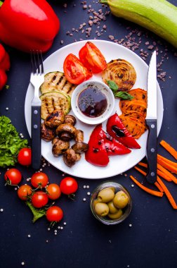 Sebze sulu ızgara sebzeler, çeşitli tatlı biberler, bebek iliği ve otlarla süslenmiş domates.