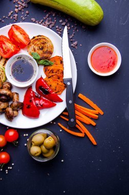 Sebze sulu ızgara sebzeler, çeşitli tatlı biberler, bebek iliği ve otlarla süslenmiş domates.