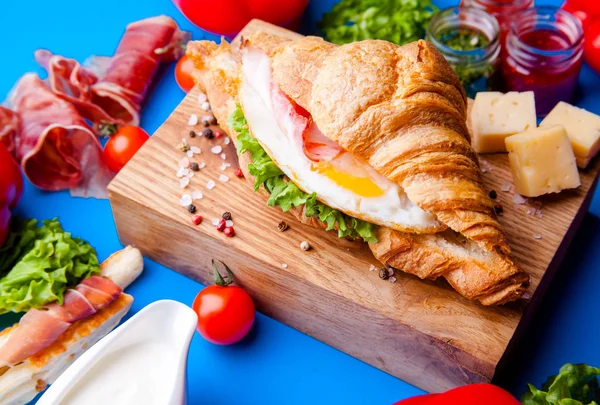 Jambonlu, peynirli, kekikli ve incirli taze kruvasan sandviçi.