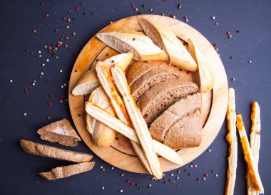 Yuvarlak tabakta dilimlenmiş siyah taze çavdar ekmeği.